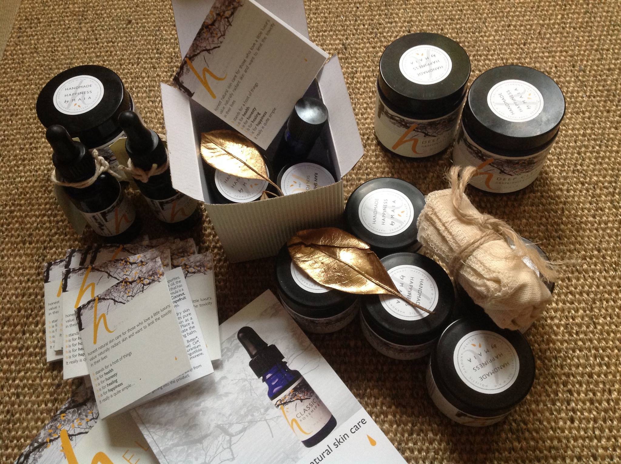 h by Maia - full range of skincare products on a natural fibre rug